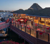 View of Hyatt Regency Mission Bay at dusk showing deck with dining tables and chairs and overlooking marina