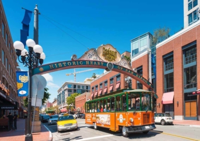An Old Town Trolley passing underneath the arch that welcomes visitors to San Diego's Gaslamp Quarter